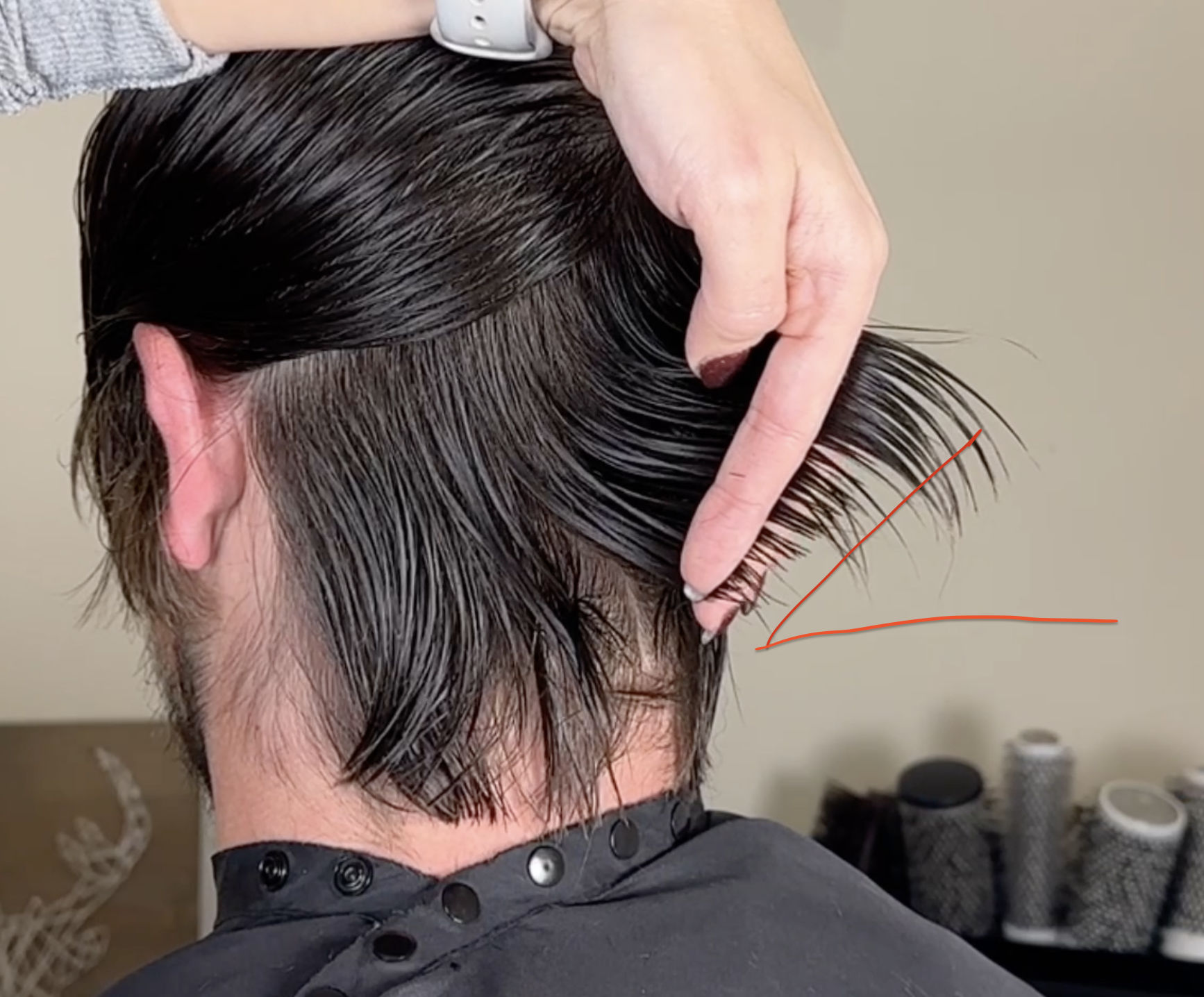 SHOWING-THE-HAIR-BEING-HELD-AT-A-45-DEGREE-ANGLE-TO-SHOW-WHERE-THE-HAIR-NEEDS-TO-BE-CUT